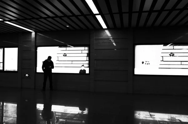 black and white photo of a man in the airport