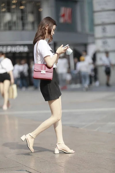 young woman with backpack walking on street