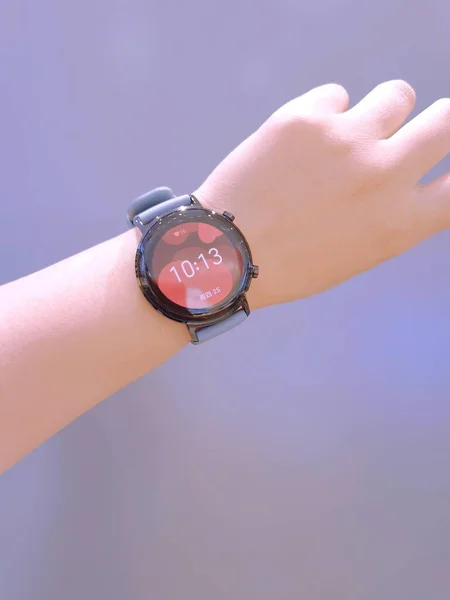 woman hand holding smartwatch on wrist watch on green background