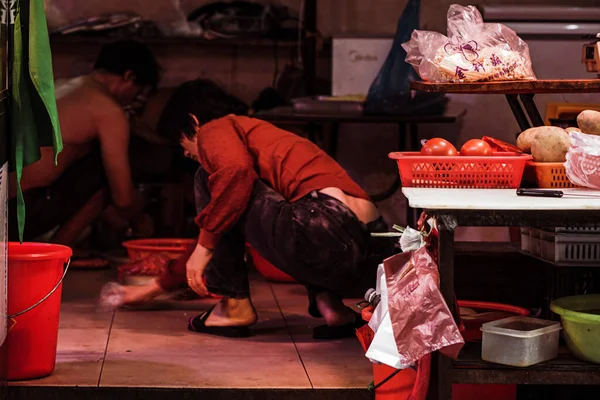 a man in a red dress with a bag of meat in the market