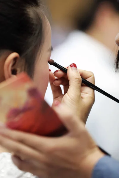 woman applying makeup artist at beauty salon