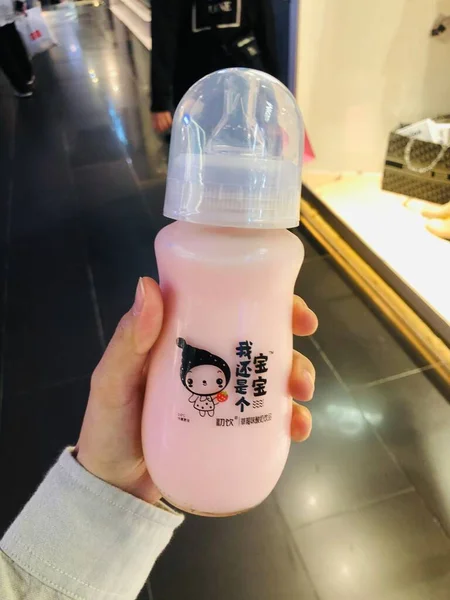 a child is pouring milk into a jar with a bottle of water