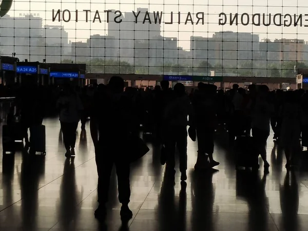 silhouettes of people walking in the airport