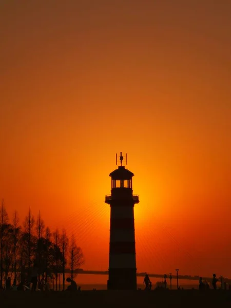 lighthouse at sunset, the silhouette of the ship