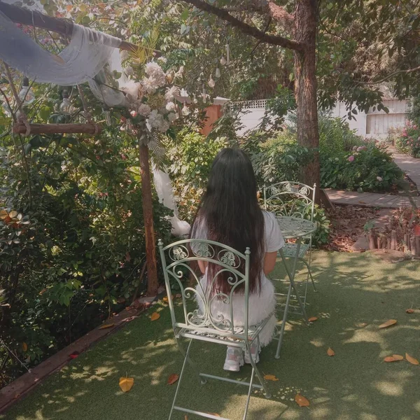 young woman sitting in a chair in the park