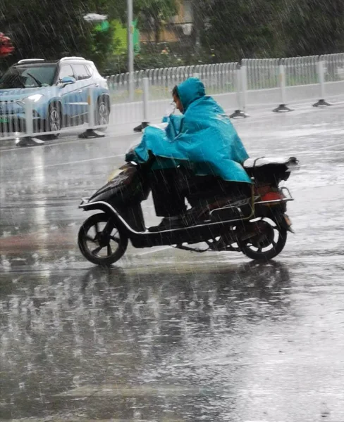 the man is riding a motorcycle in the rain