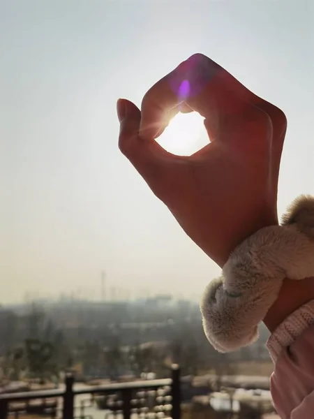 woman holding a heart in the sky