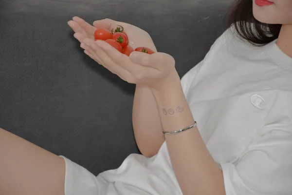 woman holding a red tomato in her hands