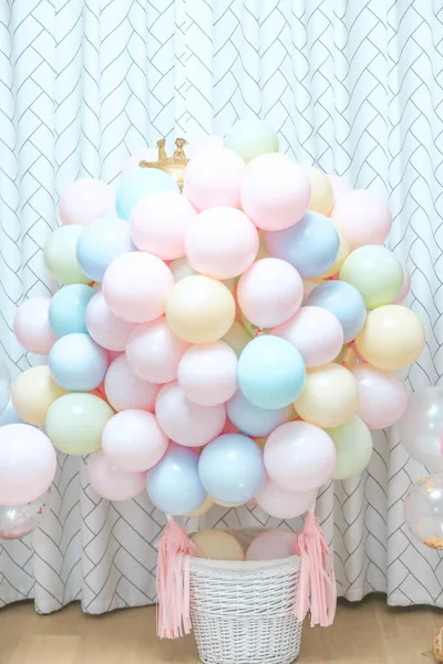 white balloons in a basket on a background of a large window.