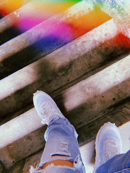 legs of a man in a rubber boots on a background of a wooden bridge