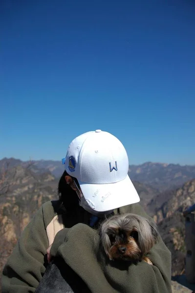 a man in a helmet with a dog in the mountains