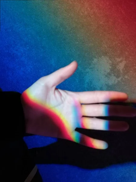 close up of a hand holding a colorful human body