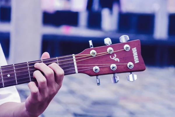 close up of a hand holding a guitar