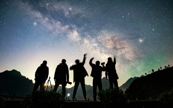 silhouette of a group of people in the night sky