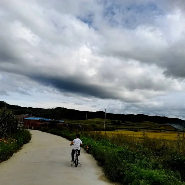 a man riding a bicycle in the countryside