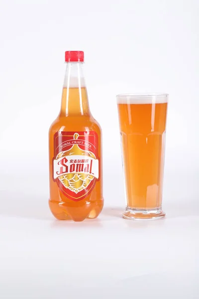 a glass of juice and a bottle of tea on a white background