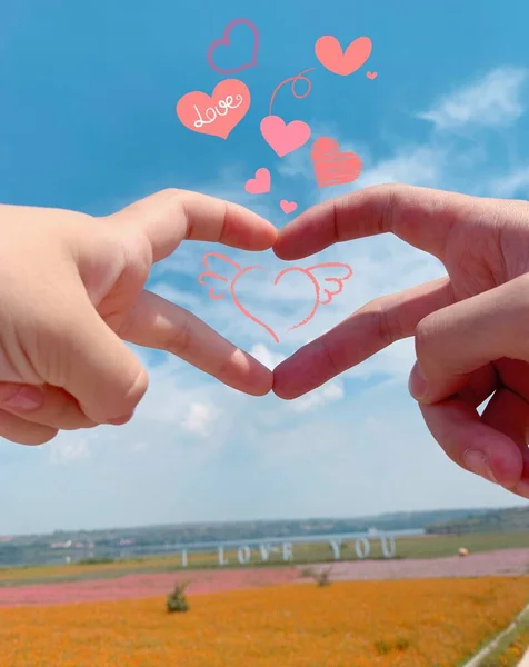 hand holding heart with love symbol on the beach