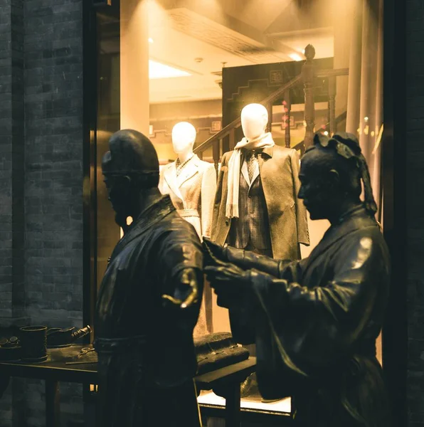 man in a suit with a mannequin in a shop