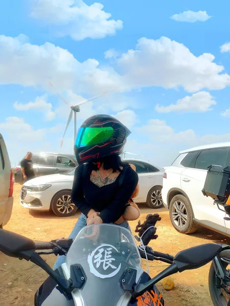 young woman with a motorcycle helmet and a beard of a motorbike