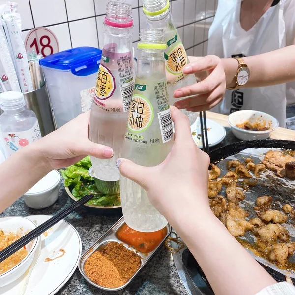 the hands of the woman is eating food to the market.