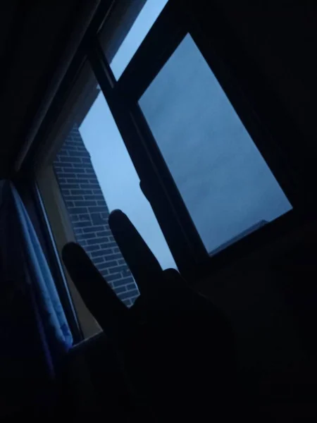silhouette of a man with a laptop on the window