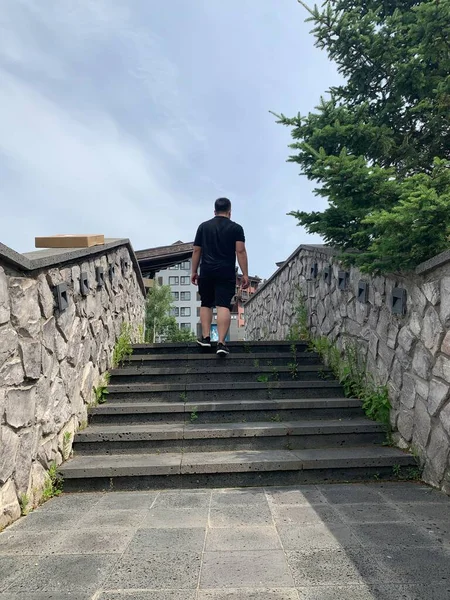 man walking on the stairs of the city