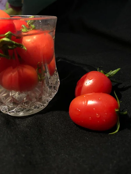 fresh tomatoes and cherry tomato on black background