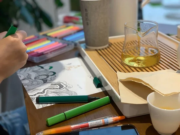 artist draws a paper cup on the table