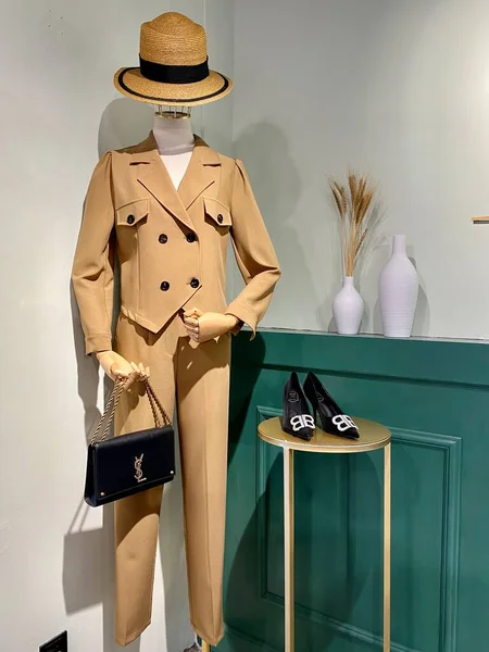 fashion mannequin with hat and bag of straw on the background of the store