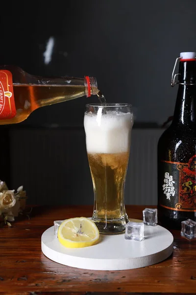 beer with ice and lemon on a dark background