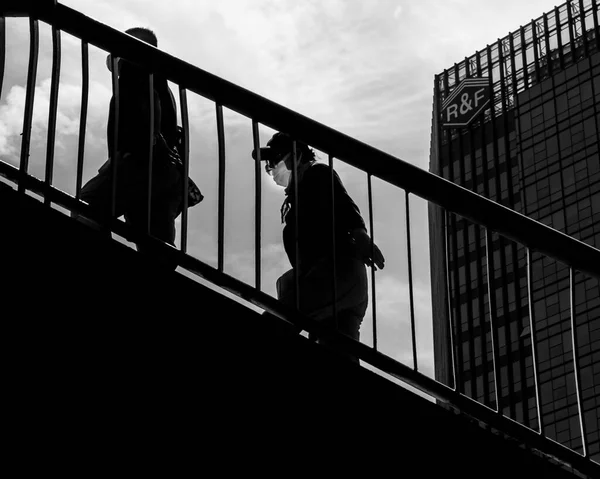 black and white photo of a man in a suit on a background of a bridge