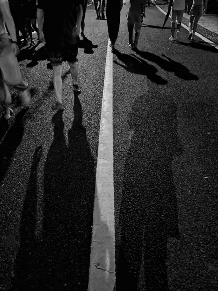 black and white photo of people walking in the city