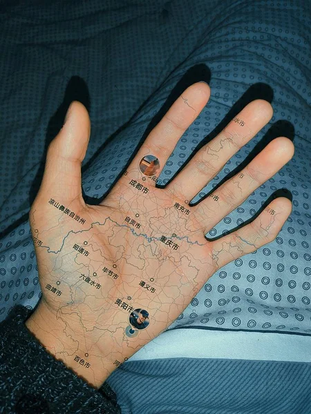 hand with a tattoo on the background of a female hands