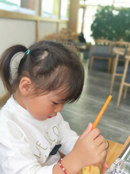 little girl draws a pencil on the table