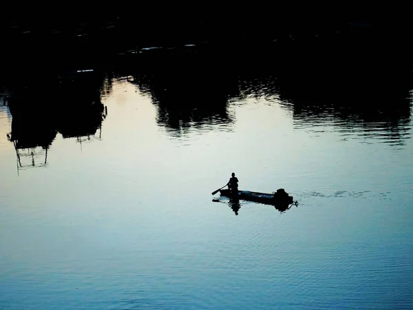 silhouette of a man in a boat on the lake