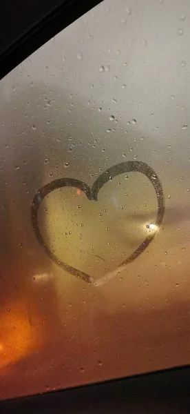 glass window with a heart on the background of the water