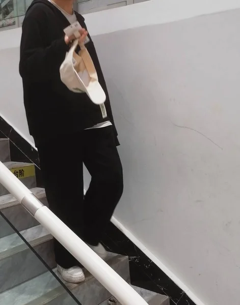 young man in suit and black pants and tie walking on stairs