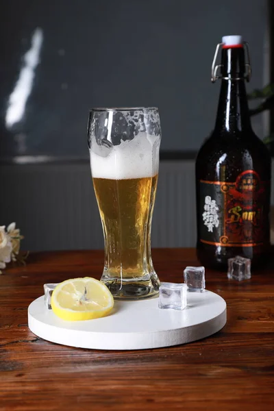 beer with ice and lemon on a wooden table