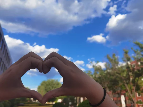 heart shape in the hands of a woman in the sky