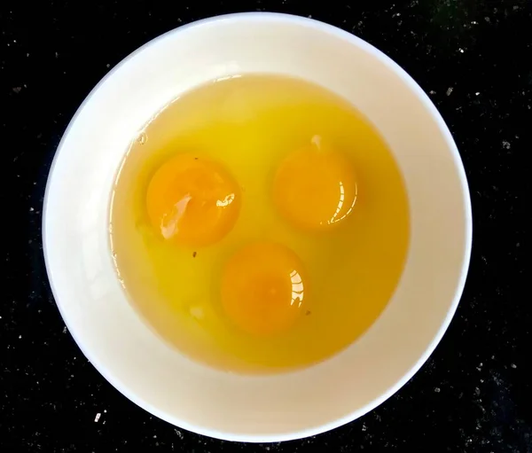 egg yolk with eggs on black background