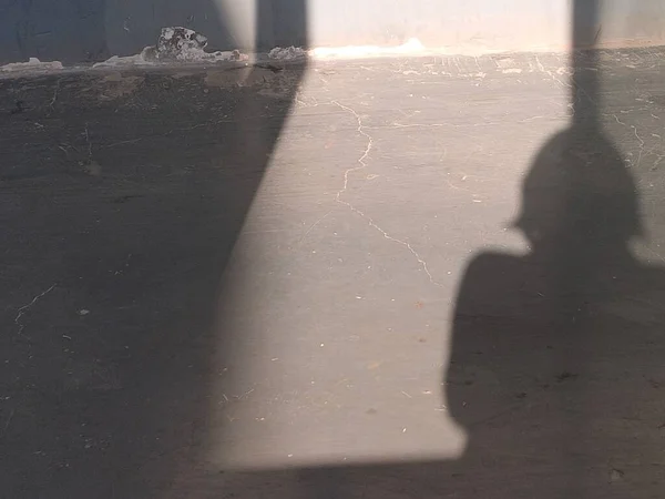 the shadow of a man in a black uniform