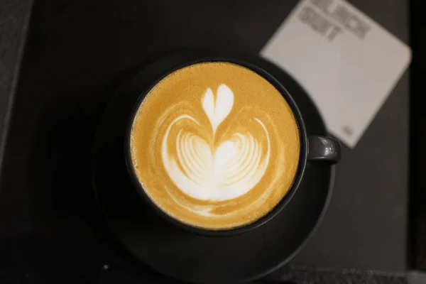 cup of cappuccino coffee with a heart on a wooden table