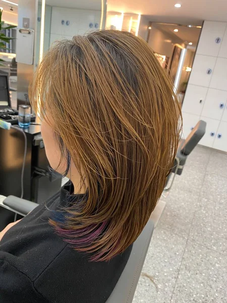 young woman with hair dryer in the salon