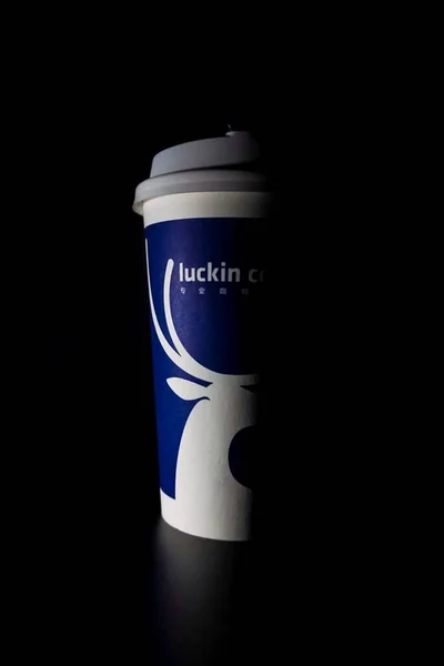 coffee cup with a lid of a paper on a black background