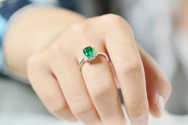 close up of a female hand holding a diamond ring