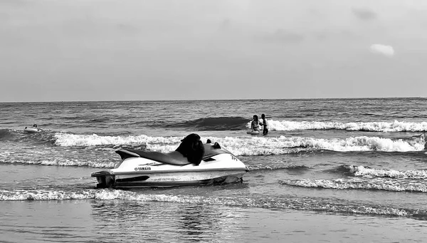 black and white photo of a man in a boat on the beach