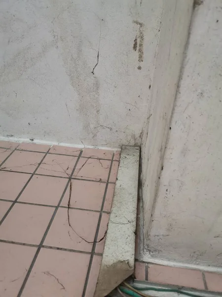 concrete floor with a wall and a white tile