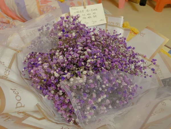 a bouquet of purple flowers in a glass vase