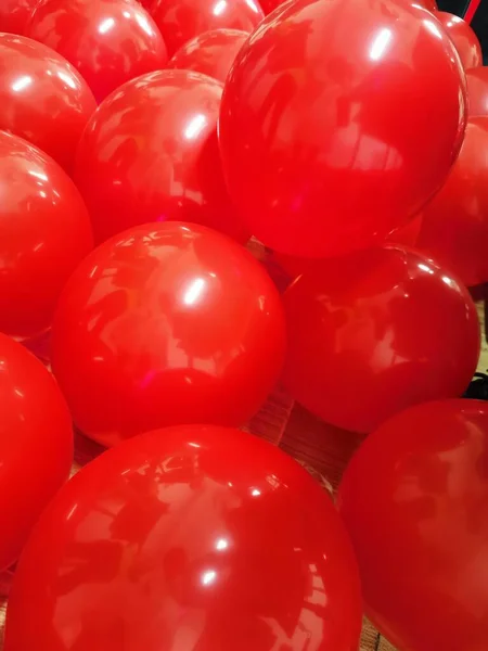 red and white balloons on a background of a large pile of colorful confetti.