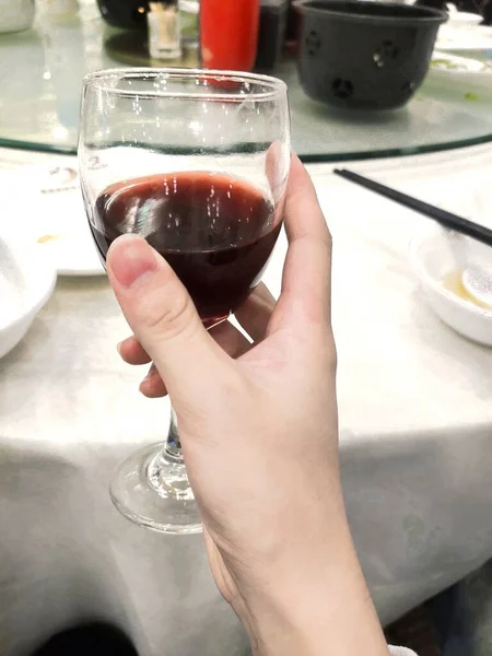 a glass of wine with a red liquid in a restaurant